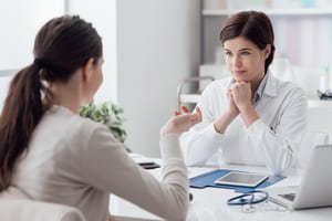 "Врач и пациентка беседуют в кабинете